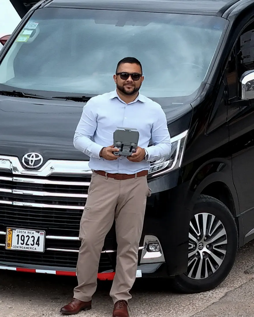 Randy Agüero standing with ASCEND's Toyota Hiace Majesty