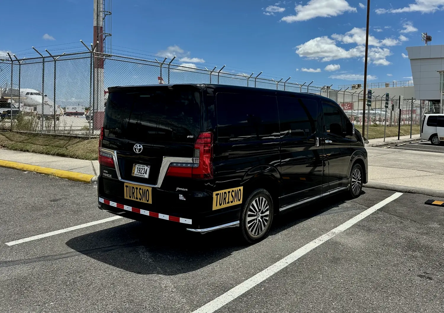 Rear three-quarter view of ASCEND's black Toyota Hiace Majesty at Liberia Airport